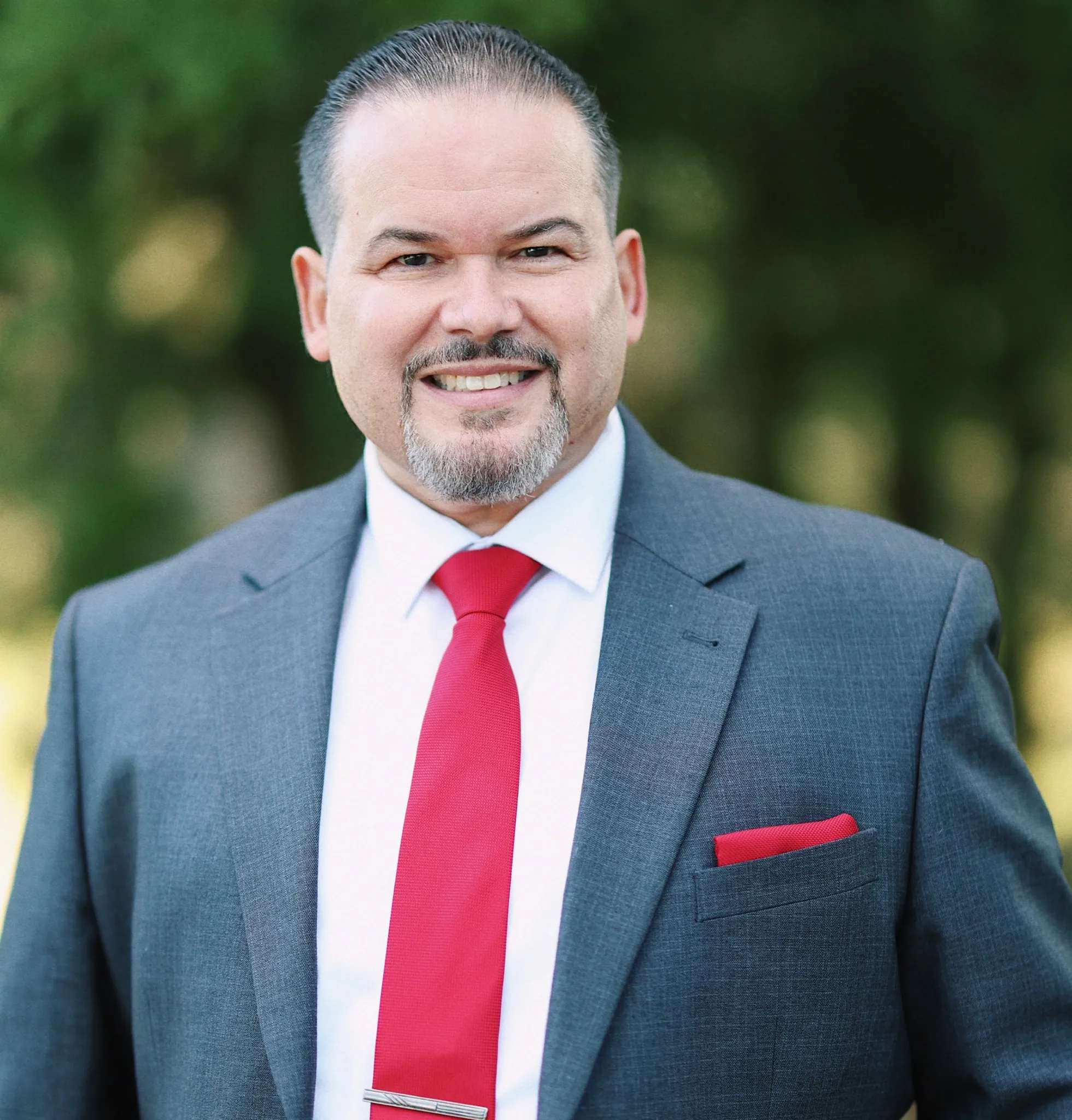 Jorge Malavet smiling and wearing a blue suit
